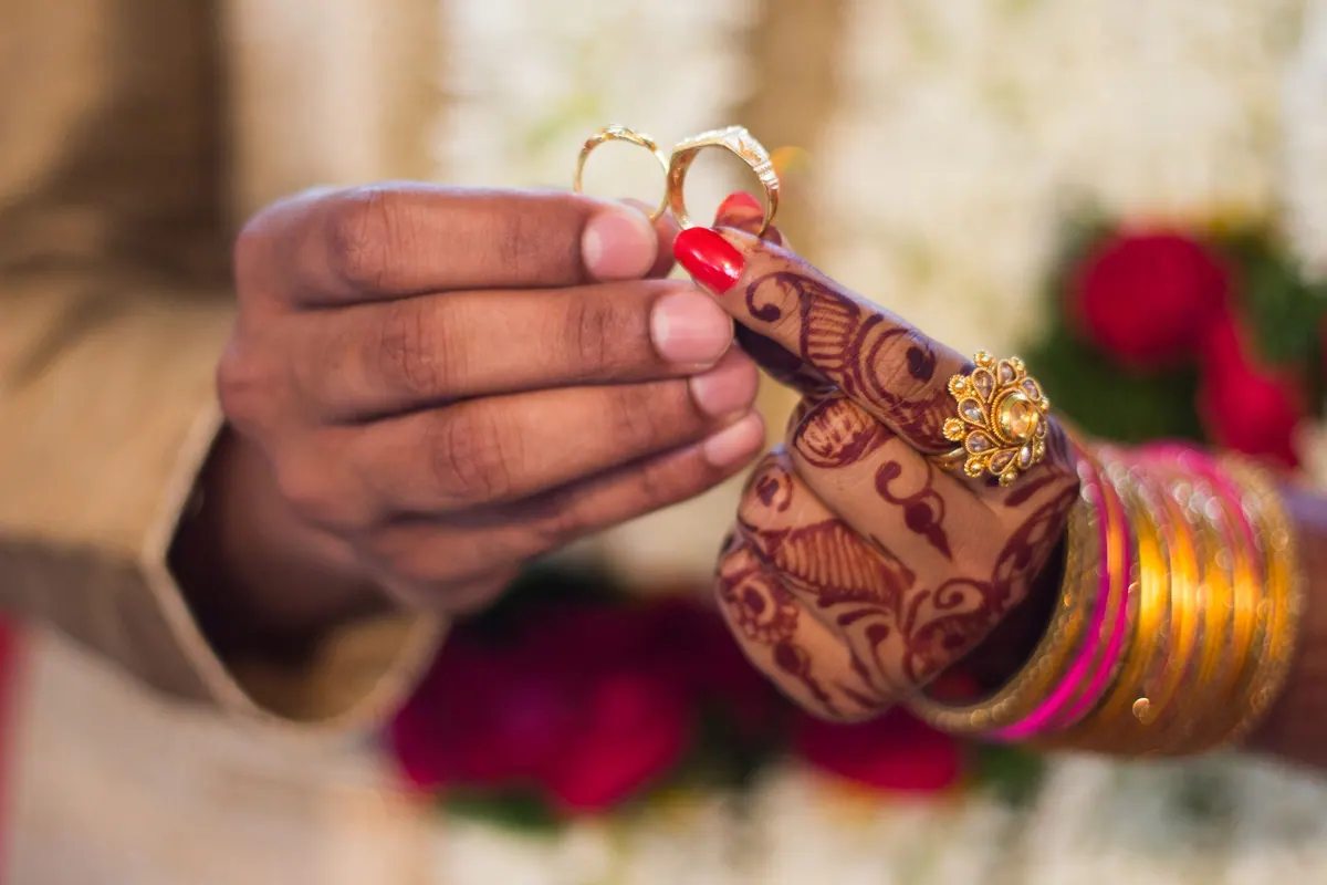 Bangled hands holding an offering during a family ceremony for a new baby