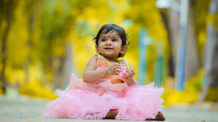 Baby in a pink dress outdoors in the afternoon light