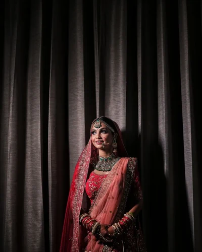 Bride photographed alone against a dark curtain before the ceremony begins