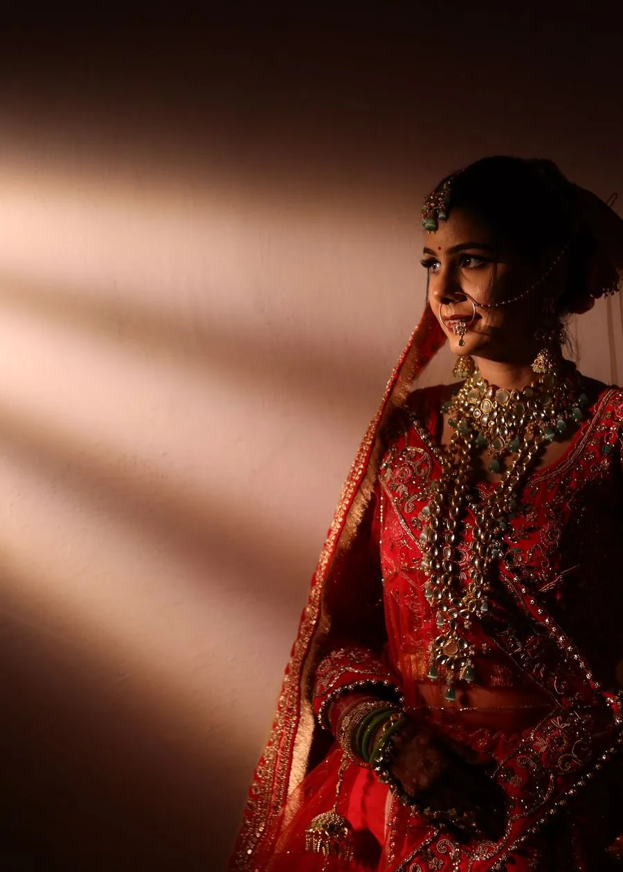 Bride photographed in a shaft of afternoon light coming through a doorway