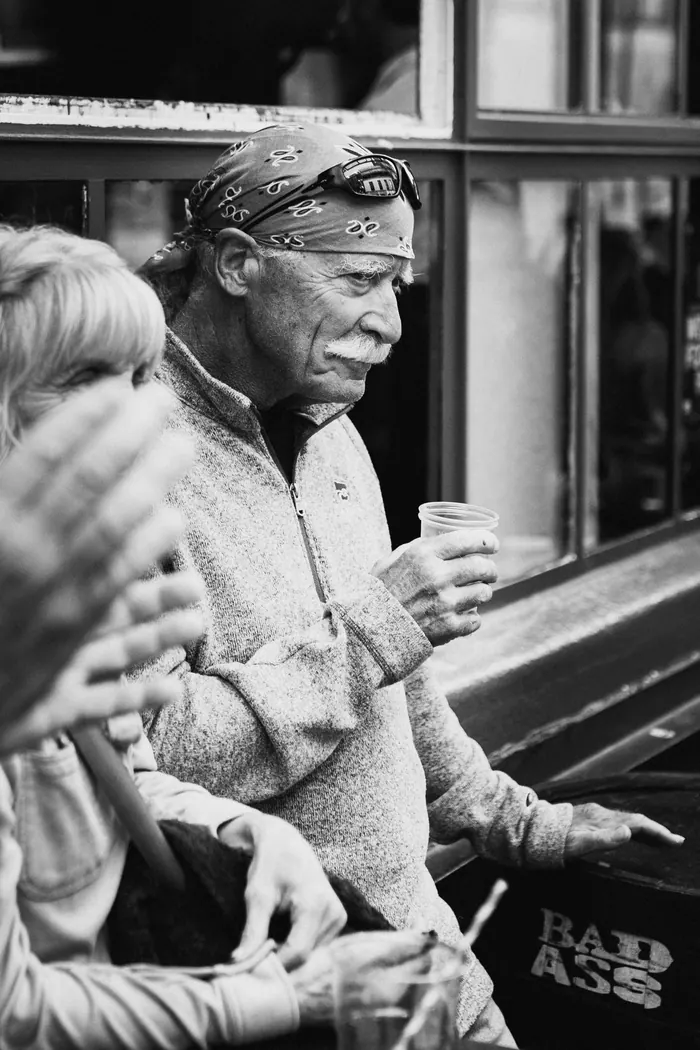 Close view of an elderly guest's hands resting on his knee during the ceremony