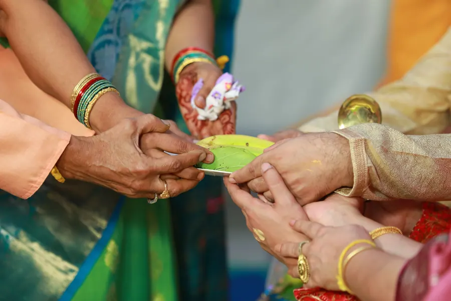 The ring being exchanged between the couple's hands at the engagement ceremony
