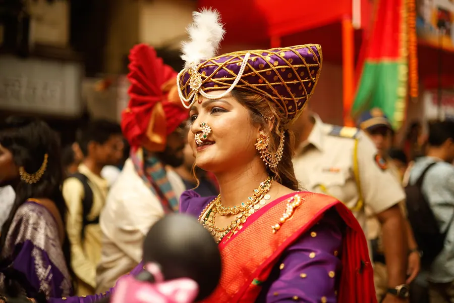 Performer in costume on stage during a cultural programme, lit from the front