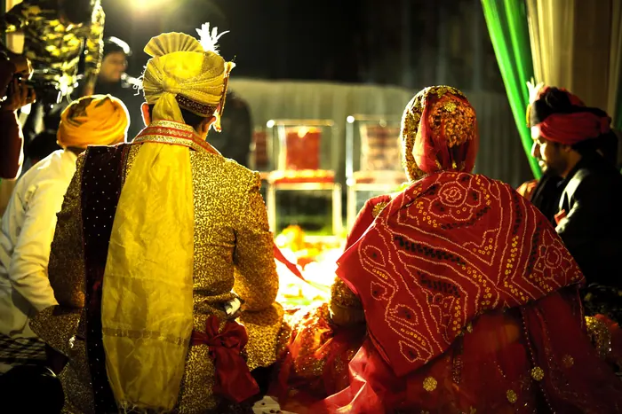 Family seated together during a godh bharai ceremony, gifts and sweets laid out
