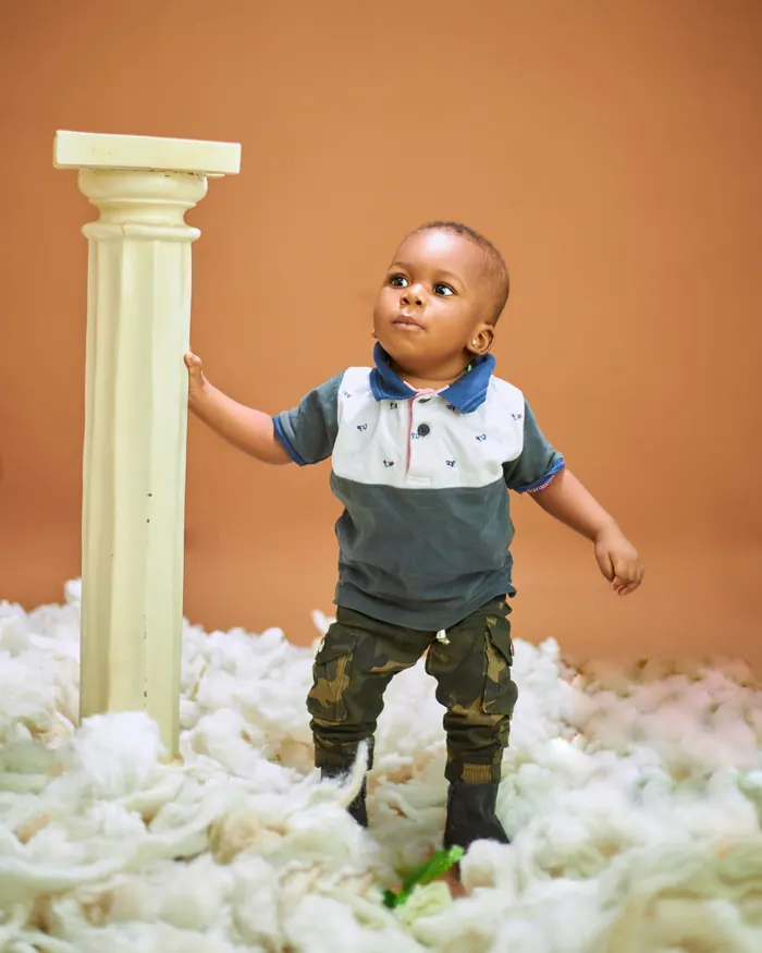 Toddler standing and holding on to a doorway, mid-step