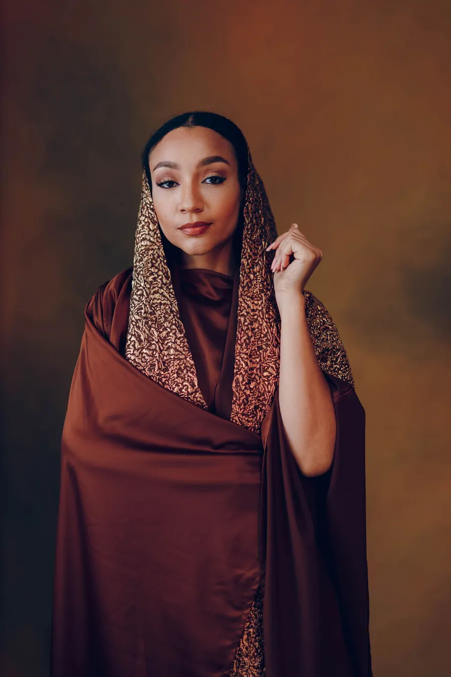 Matrimonial portrait of a woman in traditional dress against a dark background