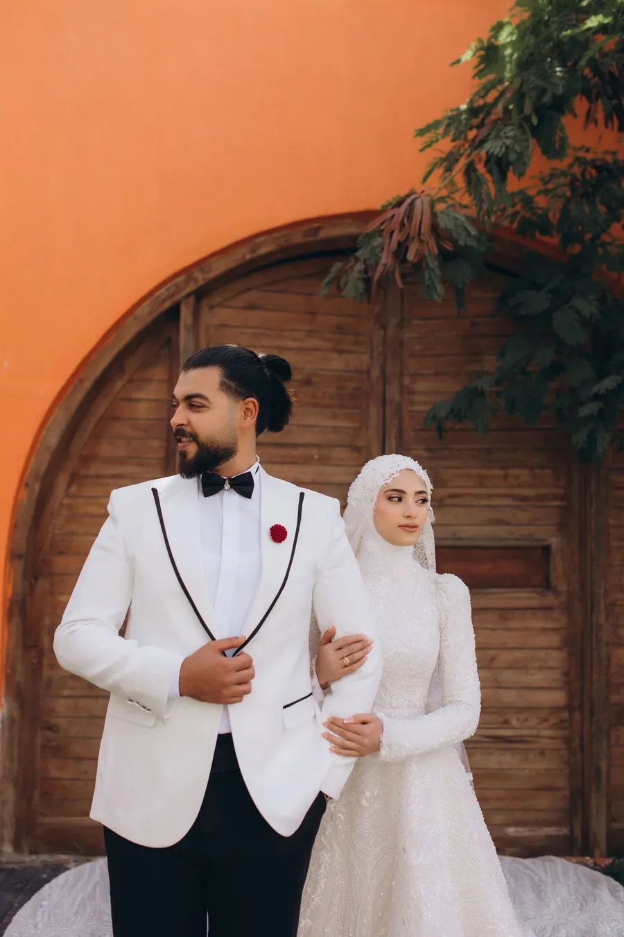 Couple photographed at the entrance arch after the nikah, the bride in an ivory gharara
