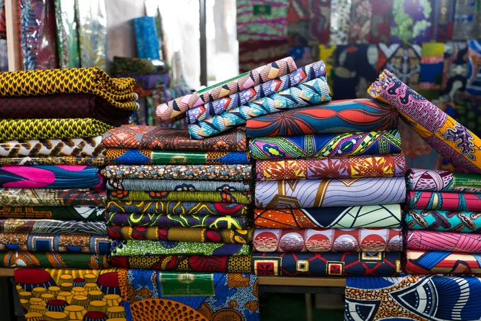 Stacked bolts of coloured textile arranged for a catalogue shoot