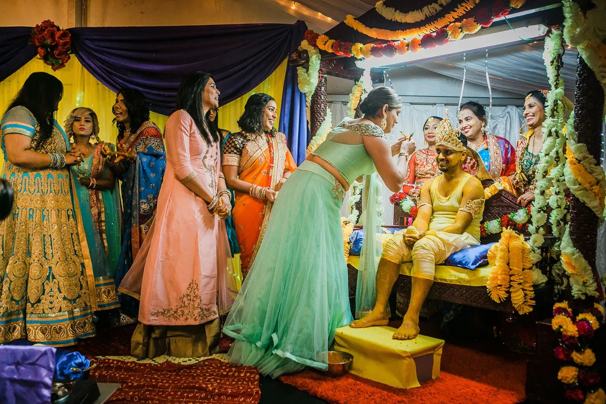 Family and guests gathered around the groom during a wedding function