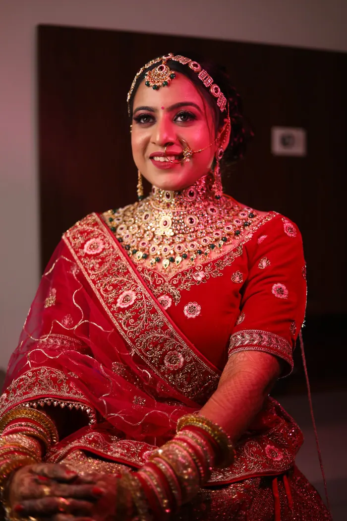 Bride laughing in a red lehenga during the ceremony