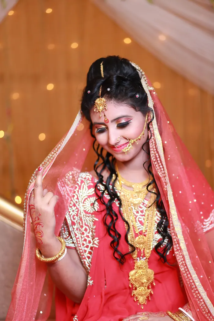 Bride under a red veil lit by evening light