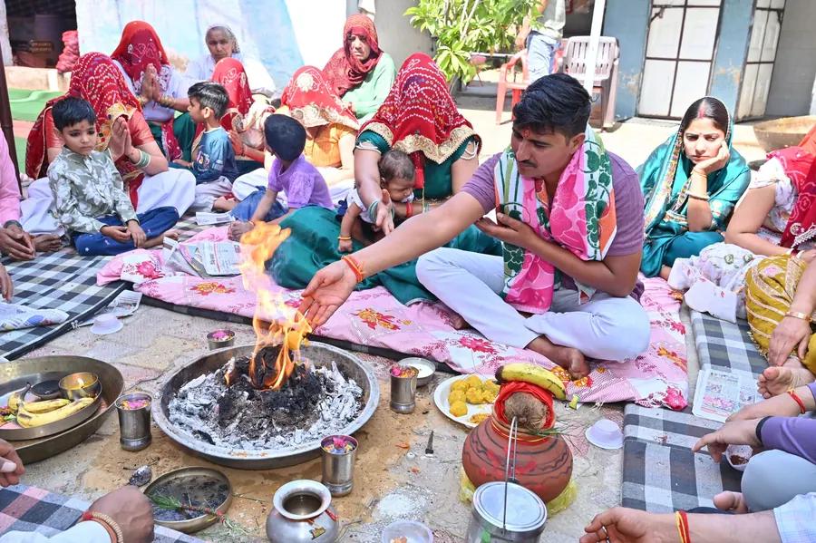 Family seated around the sacred fire during the wedding rituals, the priest guiding the offerings