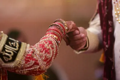Close view of the bride's bangled hands in warm, film-like colour